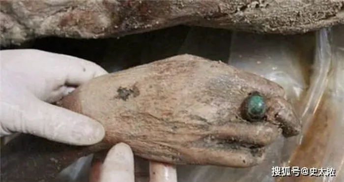 Sau khi loại bỏ lớp trang phục, các nhà khảo cổ phát hiện nhiều lớp tiền giấy thời nhà Minh giữa các lớp quần áo. Một chiếc nhẫn ngọc lục bảo cũng được phát hiện. Tuy nhiên, chiếc kẹp tóc của người phụ nữ không có giá trị bằng chiếc nhẫn.