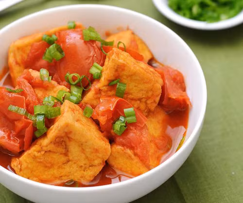 Đậu phụ sốt cà chua: Các bước thực hiện của món này bao gồm chiên giòn đậu phụ thái miếng, sốt chín cà chua rồi cho đậu phụ đã chiên vào xào cùng đến khi miếng đậu đậm đà vị nước sốt cà chua là được.