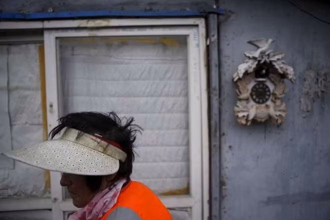 Một phụ nữ đi qua căn nhà trong khu ổ chuột cuối cùng ở Seoul. Những ngôi nhà ở đây đều xây dựng tạm bợ, không vững chắc. "Tôi rất lo lắng khi nghĩ tới tương lai mình sẽ qua đời ở nơi này", một cụ bà ở Guryong nói.