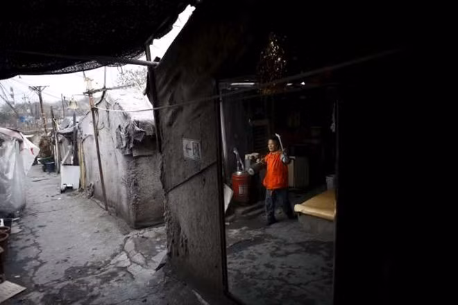 Một phụ nữ sống trong khu Guryong ở Seoul. Nơi này có khoảng 2.000 dân. Ông Ahn Young-chan, 79 tuổi, cho biết phần lớn người sống ở đây là các cụ già. Ông Ahn chuyển đến Guryong từ cuối thập niên 80.