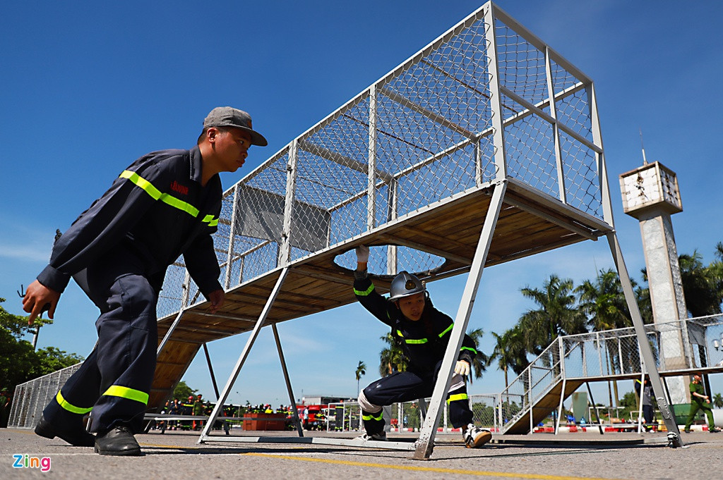 Trong phần thi chạy 100 m, một chiến sĩ phải cõng bình dưỡng khí để vượt qua mô hình không gian hạn chế.