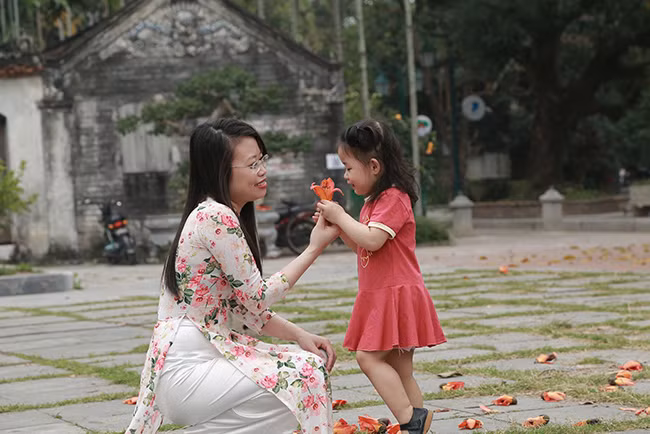 Yêu thích hoa gạo bởi vẻ đẹp bình yên chốn quê nhà, hay tin hoa gạo đã nở, chị Đặng Mai Phương cùng gia đình từ quận Hoàng Mai về chùa Thầy để chụp ảnh, đồng thời giới thiệu cho các con biết thêm về hoa gạo và nguồn ngốc của cây gạo ở ngôi chùa cổ kính, linh thiêng.