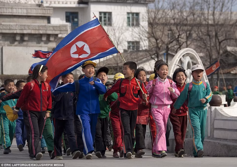 Trong số đó, những hình ảnh về thủ đô Bình Nhưỡng của Triều Tiên nhận được rất nhiều sự chú ý. Trong ảnh là cảnh tượng trẻ em hào hứng đến trường, trên vai là lá cờ Tổ quốc. (Nguồn Dailymail)