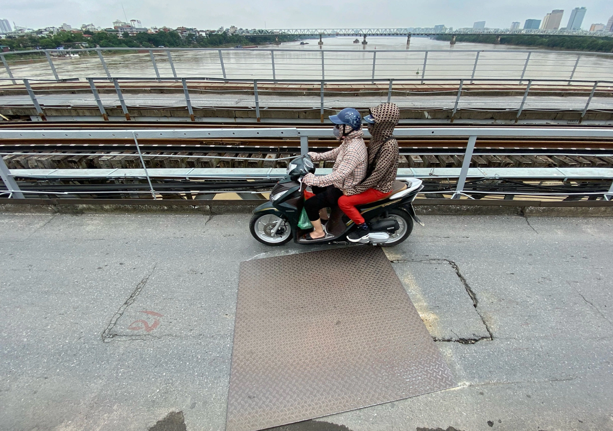 Một số vị trí mặt cầu Long Biên bị nứt vỡ gây nguy hiểm cho người đi đường được đơn vị quản lý cầu che chắn tạm thời bằng tấm thép lớn.