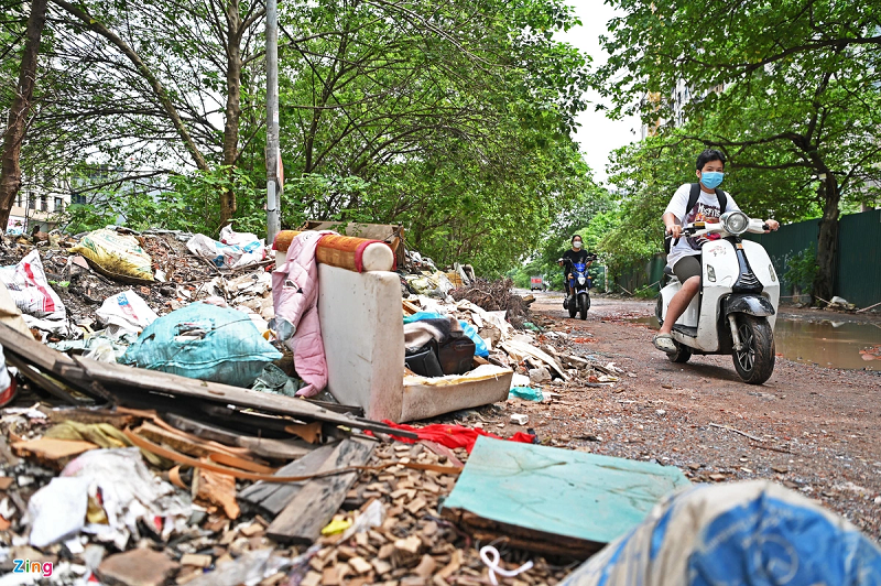 Hai bên tuyến đường tràn ngập phế thải và vật liệu xây dựng. Cây cối nhiều năm qua cũng không được chăm sóc, cắt tỉa.