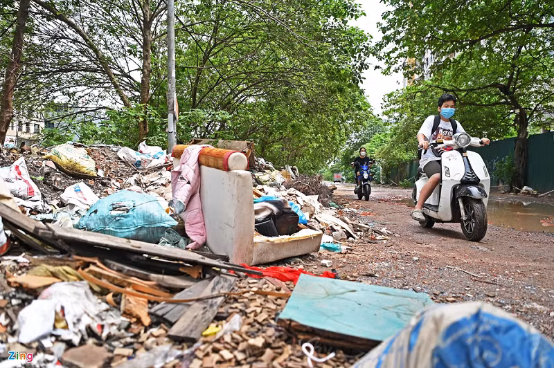 Hai bên tuyến đường tràn ngập phế thải và vật liệu xây dựng. Cây cối nhiều năm qua cũng không được chăm sóc, cắt tỉa.