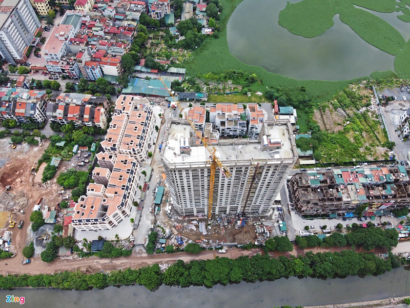 Trong hình là dự án Thanh Bình Garden cao 21 tầng với khoảng 255 căn hộ. Dự án đang trong giai đoạn hoàn thiện và dự kiến bàn giao vào quý IV năm nay. Tuy nhiên, phía lối vào vẫn là con đường với hàng loạt ổ voi. Một nhân viên tư vấn bán hàng cho biết dự án hiện chưa mở bán nhưng đã có mức giá dự kiến 38-40 triệu đồng/m2.