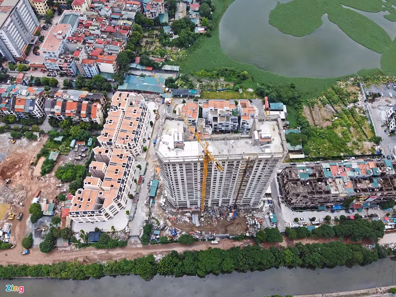 Trong hình là dự án Thanh Bình Garden cao 21 tầng với khoảng 255 căn hộ. Dự án đang trong giai đoạn hoàn thiện và dự kiến bàn giao vào quý IV năm nay. Tuy nhiên, phía lối vào vẫn là con đường với hàng loạt ổ voi. Một nhân viên tư vấn bán hàng cho biết dự án hiện chưa mở bán nhưng đã có mức giá dự kiến 38-40 triệu đồng/m2.