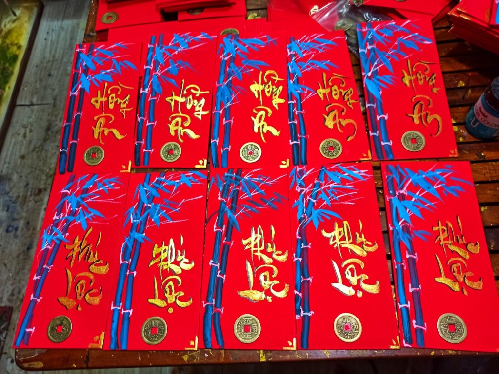 Màu đỏ của bao lì xì tượng trưng cho màu của như ý. Anh Đạt nhớ lại sự tích gắn liền với phong bao lì xì từ thời xưa, khi 8 vị tiên thấy yêu quái quấy phá trẻ em khi ngủ, liền hóa thành một đồng xu nhỏ nằm kế bên trẻ nhỏ hòng đuổi tà ma. Cha mẹ thấy vậy liền gói vào trong túi đỏ rồi đặt dưới gối để em ngủ ngon hơn.