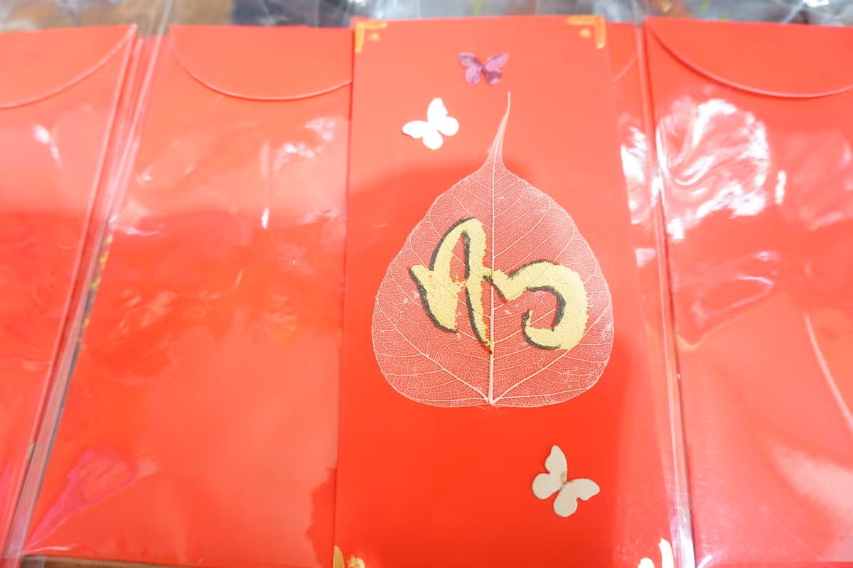 Có những bao lì xì trang trí rất giản dị, tận dụng những sản phẩm handmade. Nhận thấy vẻ đẹp mộc mạc ấy đang dần bị mai một, nghệ nhân Nguyễn Tấn Đạt (ngụ quận 3, TP. HCM) đã nảy ra ý tưởng thiết kế bao lì xì thủ công kết hợp với chữ thư pháp.