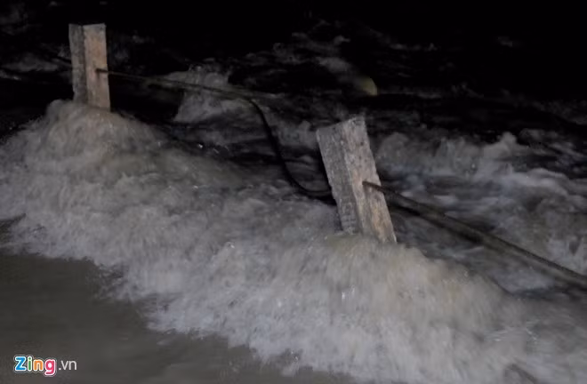 Nước lũ cuồn cuộn băng qua Tỉnh lộ 640 ở huyện Tuy Phước. 