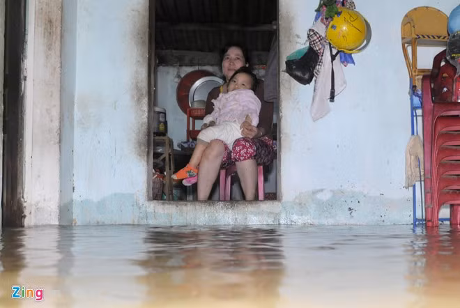 Tối 3/11, nước lũ ào ạt tràn vào nhà khiến bà Trương Thị Loan ôm cháu gái (ngụ ở xã Phước Nghĩa) lo lắng.