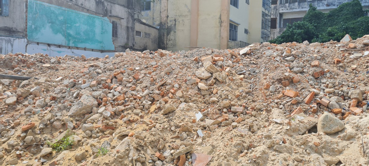 Và phía sau hàng rào là... đống rác thải xây dựng "cao như núi".