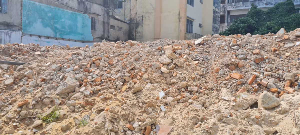 Và phía sau hàng rào là... đống rác thải xây dựng "cao như núi".