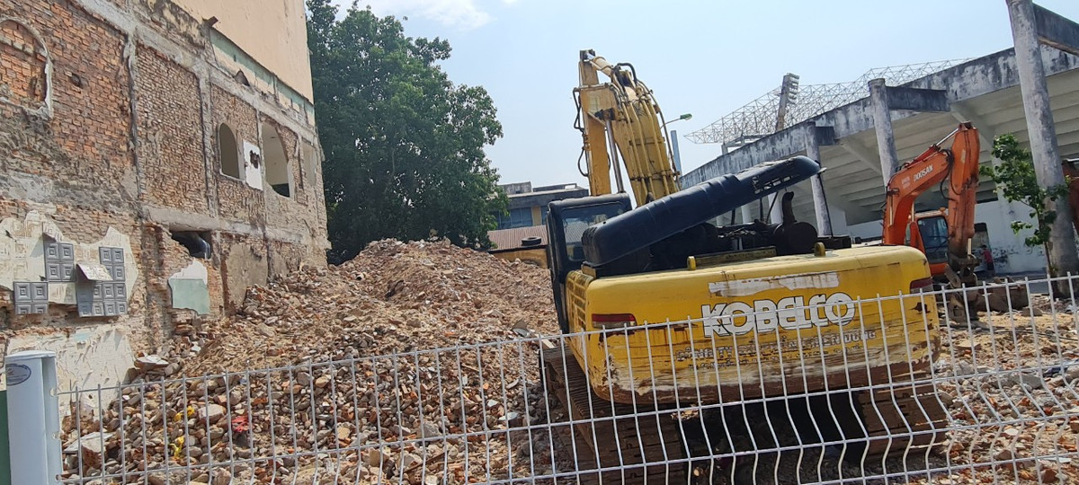 Bên trong hàng rào, các phương tiện phục vụ cho quá trình tháo dỡ nằm ngổn ngang giữa đống gạch vụn.