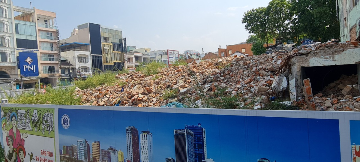 Gạch vỡ, rác thải xây dựng ngổn ngang chực tràn ra ngoài lớp rào chắn được sơn vẽ cẩn thận.