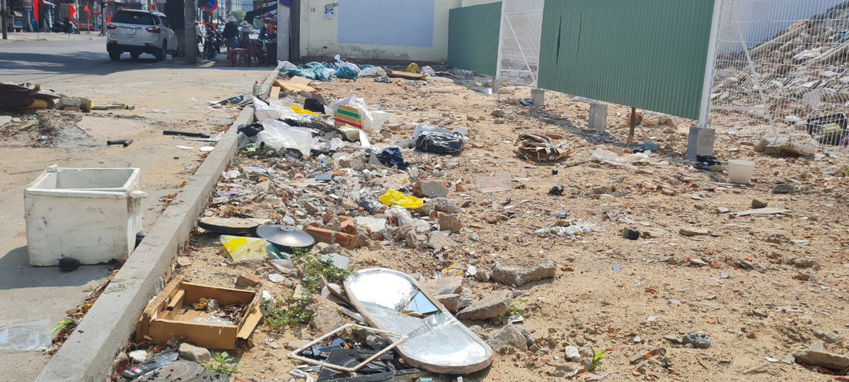 Rác la liệt cả trong và ngoài hàng rào, tràn ra lòng đường.