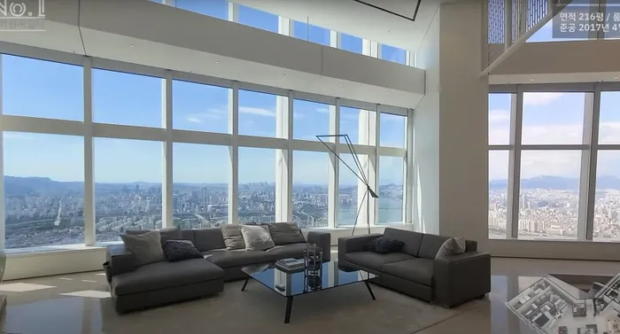 Mới đây, đài tvN đã hé lộ căn hộ của cặp vợ chồng son Jiyeon - Hwang Jae Gyun. Tổ ấm mà cặp đôi đang sinh sống là một căn penthouse 2 tầng sang trọng nằm trên tầng 42 của tòa nhà Lotte Signiel nổi tiếng. Theo thông tin được cung cấp, căn hộ có diện tích rộng 714m2 và được định giá lên đến 37 tỷ KRW (tương đương 655 tỷ đồng). Tại phòng khách, một bộ sofa cỡ lớn với tông đen chủ đạo được đặt giữa nhà. Xung quanh được bao bọc bởi lớp cửa kính đón trọn ánh sáng vào trong 