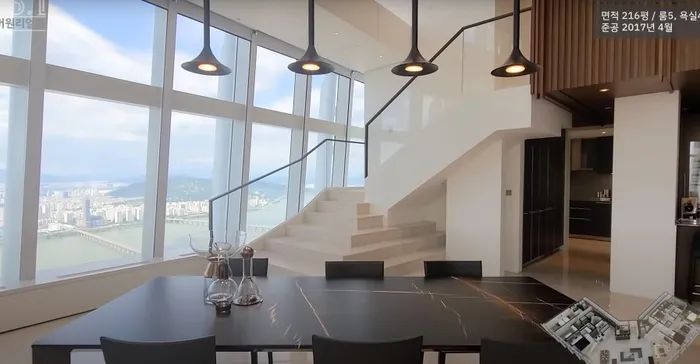 Căn nhà được thiết kế theo phong cách nội thất hiện đại, tối giản với 2 gam màu chủ đạo là đen và trắng. Căn nhà còn được lắp đặt một hệ cửa kính khổng lồ để đón ánh sáng từ bên ngoài vào, cũng như giúp chủ nhân có view ngắm cảnh "bạc tỷ"'. Phòng ăn có một chiếc bàn ăn lớn được đặt ở trung tâm, phía trên lắp hệ đèn chiếu sáng có thiết kế vô cùng độc đáo. Có thể thấy, từ không gian này căn nhà đã được điểm xuyết thêm tông màu nâu trầm giúp mang lại cảm giác gần gũi và ấm cúng hơn rất nhiều.