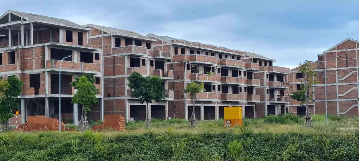 Cỏ dại ngập lối quanh những căn biệt thự chỉ mới được xây thô.