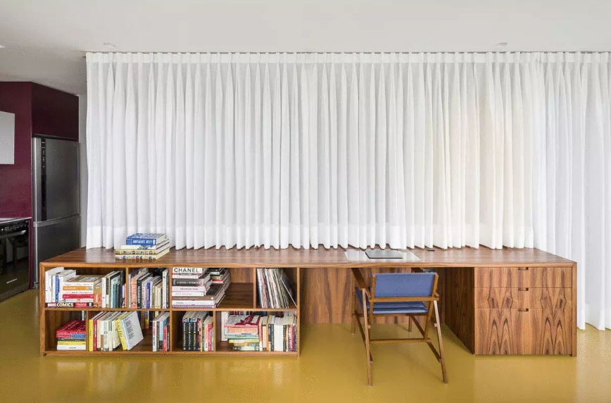 Thay vì những bức tường vững chắc, phòng ngủ được bao bọc bằng đồ nội thất tùy chỉnh và rèm vải. Đó là một cách tiếp cận linh hoạt hơn và hoạt động tốt hơn trong bối cảnh trang trí phòng thu hiện đại.