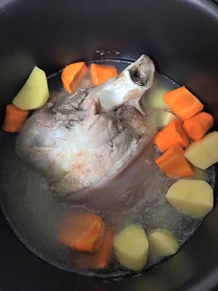 Ninh chân giò, khoai tây và cà rốt với nồi áp suất cho mềm nhừ.