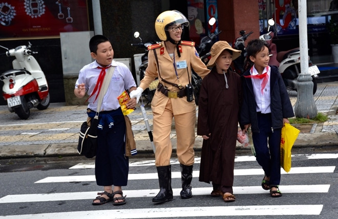 Trong khi nhiều chiến sĩ công an vẫn hàng ngày thầm lặng cống hiến, hy sinh vì cuộc sống bình yên của nhân dân (trong ảnh là nữ chiến sĩ công an Đà Nẵng đưa các em nhỏ qua đường- ảnh: CAND), thì những CSGT vừa bị kỷ luật thực sự là những con sâu làm rầu nồi canh.
