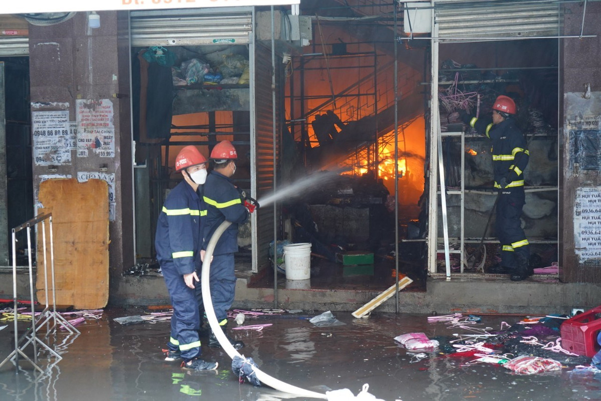 Lực lượng chữa cháy đã nhanh chóng triển khai các phương án khống chế, không cho đám cháy lan sang khu vực các nhà bên cạnh; đồng thời sơ tán dân ra khỏi khu vực cháy, cứu tài sản cho người dân, sẵn sàng cứu thương khi có sự cố. (Ảnh: Đàm Thanh) 