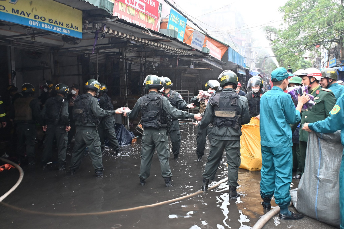 Nhiều hàng hóa được cứu hộ di chuyển ra khỏi khu vực cháy.