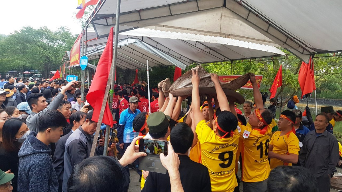 Nhiều người đàn ông to khỏe cùng nâng pháo giúp pháo thủ.