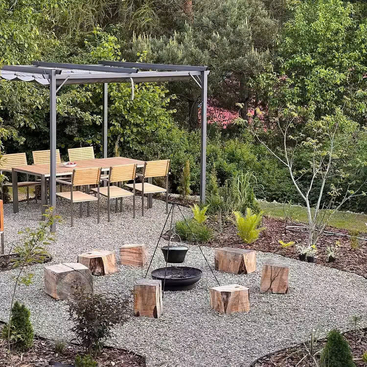 Tái sử dụng gốc cây thành ghế ngồi sân sau có khu vực đốt lửa trại và khu vực ăn uống ngoài trời.