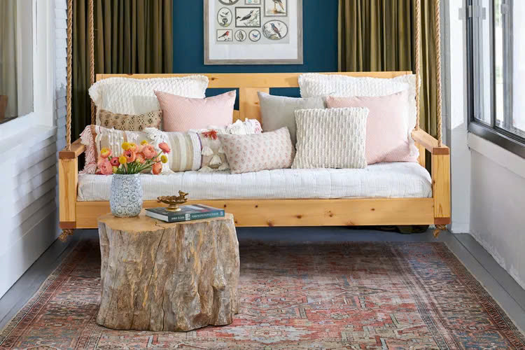 Một gốc cây lớn được dùng như bàn cà phê trong phòng tắm nắng tạo nên sự kết hợp hoàn hảo giữa trong nhà và ngoài trời.