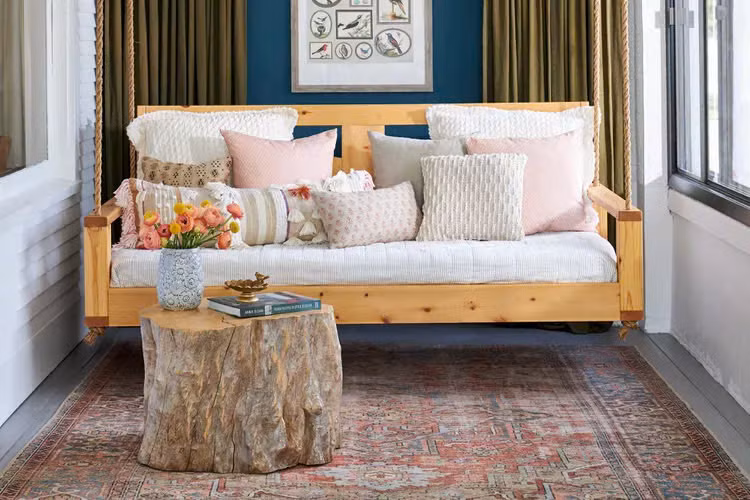 Một gốc cây lớn được dùng như bàn cà phê trong phòng tắm nắng tạo nên sự kết hợp hoàn hảo giữa trong nhà và ngoài trời.