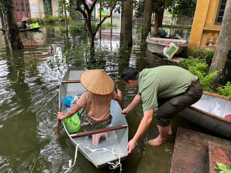 Lực lượng Công an hỗ trợ đưa người dân đến nơi an toàn. 