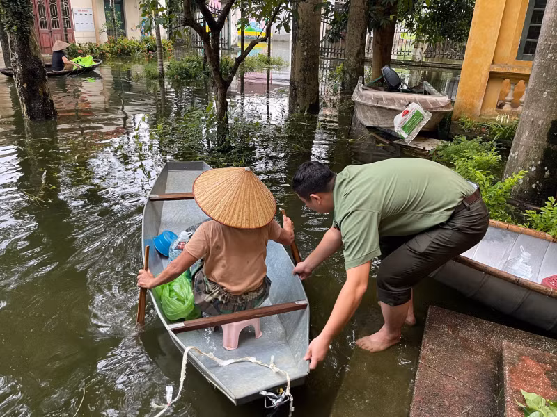 Lực lượng Công an hỗ trợ đưa người dân đến nơi an toàn. 