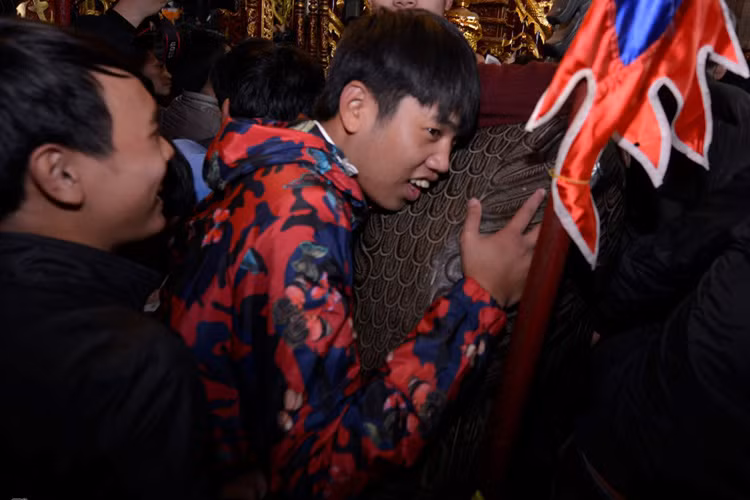 Nam thanh niên ôm con hạc tại phủ Thiên Trường một lúc lâu dù cho bên cạnh đang chen lấn xô đẩy.