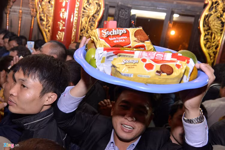 Dù gặp khó khăn do bị nhiều người xô đẩy nhưng nhiều nam thanh niên vẫn cố gắng dâng đồ lễ.