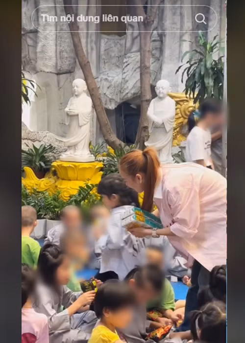 Vợ chồng Trường Giang hỗ trợ con gái lúc trao quà. Ảnh: FBNV.