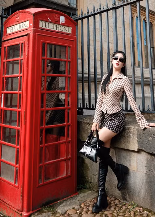 Hình ảnh Huyền My tạo dáng bên cạnh bốt điện thoại màu đỏ của Anh.