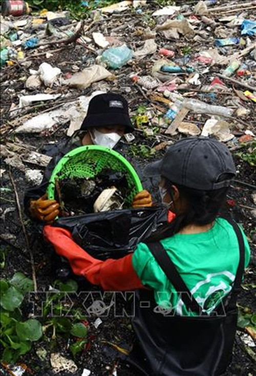 Nhiều thành viên trong nhóm Hà Nội Xanh dầm mình dưới sông để vớt rác.