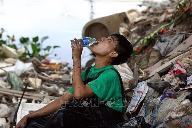 Phút nghỉ ngơi sau mấy giờ đồng hồ dầm mình gom rác dưới sông "đen".