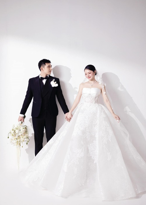 Midu diện chiếc váy cưới trắng lộng lẫy còn Minh Đạt mặc vest đen.