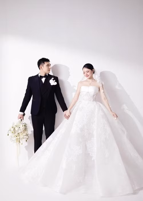 Midu diện chiếc váy cưới trắng lộng lẫy còn Minh Đạt mặc vest đen.