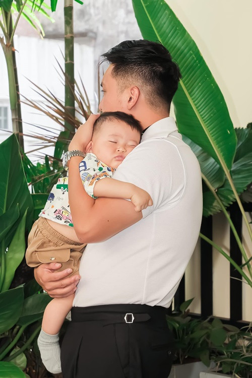 Nam doanh nhân bồng bế con ngủ tại sự kiện.