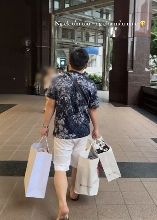 Đỗ Mỹ Linh khoe chồng xách đồ khi cả hai đi mua sắm.