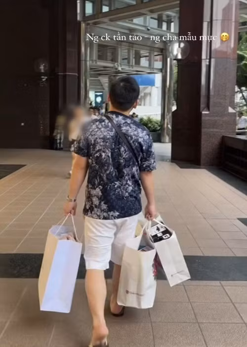 Đỗ Mỹ Linh khoe chồng xách đồ khi cả hai đi mua sắm.