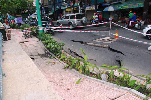 Vết nứt kéo dài, mặt nhựa đường bị lún xuống rất nhanh và tạo thành nhiều hố nhỏ khoét hàm ếch và tiếp tục có dấu hiệu lún sâu, kéo dài từ đường đến hơn nửa vỉa hè bờ kênh.