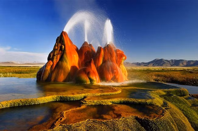  Mạch nước phun Fly Geyser được hình thành trong quá trình khoan giếng ở bang Nevada vào năm 1964. Các khoáng chất theo nước phun trào lên từ điểm khoan giếng và tích tụ thành khối hình nón trên bề mặt. Màu của khoáng chất kết hợp với tảo tạo thành khung cảnh siêu thực quanh mạch nước phun này.