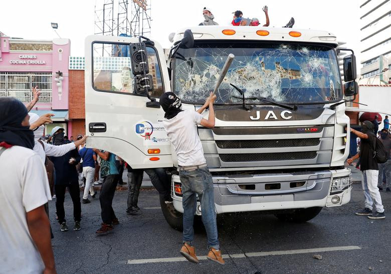 Người biểu tình đập phá chiếc xe tải trong cuộc biểu tình của những người ủng hộ phe đối lập tại Caracas.