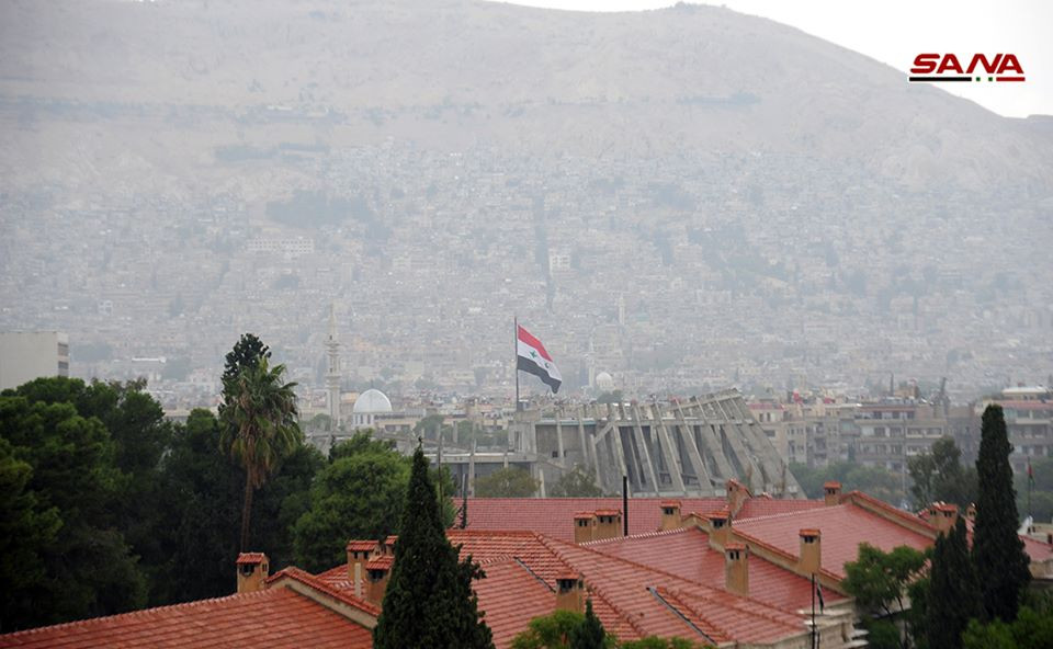 Lá cờ Syria tung bay trên nóc một tòa nhà ở Damacus. Ảnh: SANA.